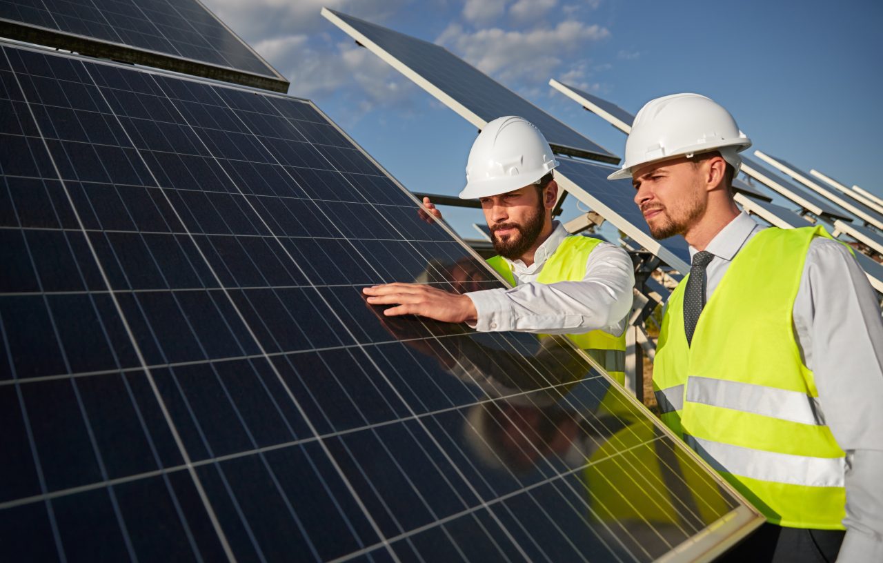 technicians examining solar panels